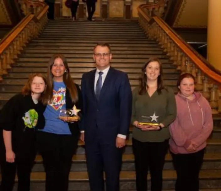 2023 EMA winners with Lt. Governor Adam Gregg and their mentees, standing in front of a staircase