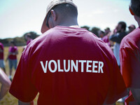 Back of adult male wearing a red t-shirt with the word volunteer on it
