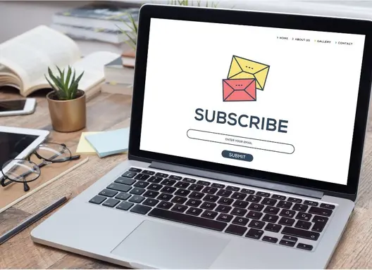 Open laptop with the word subscribe and envelope icons displayed on the screen